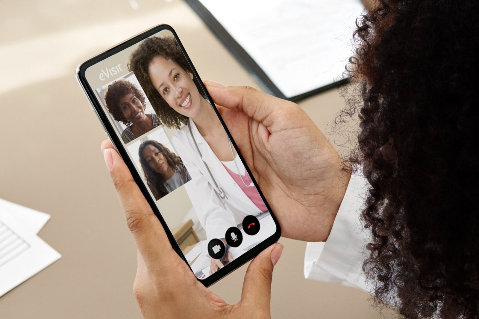 A patient on an eVisit multi-party telehealth visit with their doctor, on mobile.
